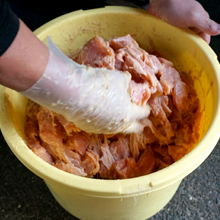 まんぷく亭のどぶ漬けの調理方法。漬け込んだ鶏肉に小麦粉と片栗粉を加え、揉んでいる